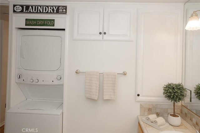 bathroom featuring stacked washer / drying machine