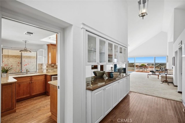 2005 Yacht Resolute, Newport Beach, CA 92660 - bar area featuring plenty of natural light, light wood finished floors, a sink, high vaulted ceiling, and tasteful backsplash