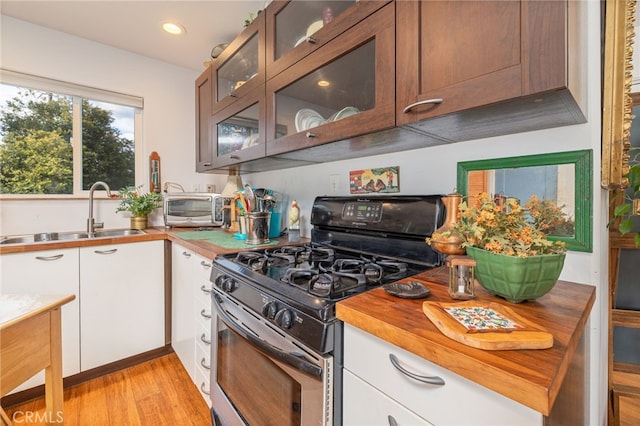 5664-5668 Clouds, Mariposa, CA 95338 - kitchen with stainless steel range with gas stovetop, a sink, butcher block counters, white cabinets, and glass insert cabinets