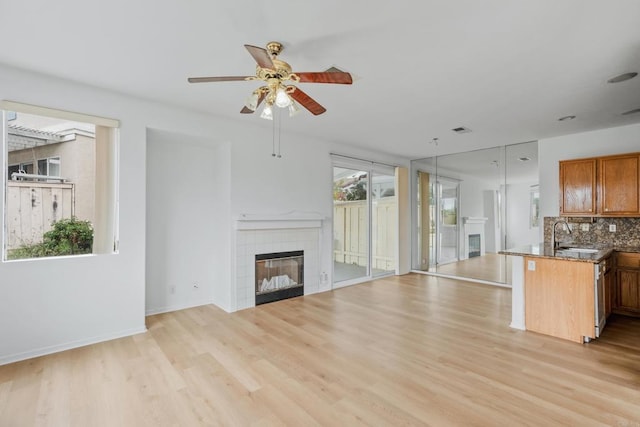 8580 New Salem St Unit 7, San Diego, CA 92126 - unfurnished living room with ceiling fan, light wood-style flooring, a fireplace, a sink, and baseboards