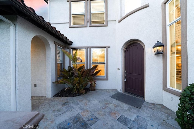 26 Upland, Irvine, CA 92602 - view of exterior entry featuring stucco siding and a patio