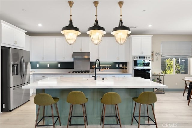 920 Bunkhouse Dr, Rancho Mission Viejo, CA 92694 - kitchen featuring stainless steel appliances, under cabinet range hood, recessed lighting, light wood-type flooring, and white cabinetry