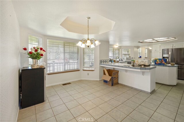 50711 Rd 426, Oakhurst, CA 93644 - kitchen featuring stainless steel fridge with ice dispenser, tile countertops, a peninsula, a chandelier, and light tile patterned floors