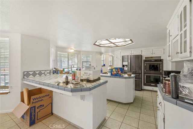 50711 Rd 426, Oakhurst, CA 93644 - kitchen with stainless steel refrigerator with ice dispenser, tile countertops, light tile patterned flooring, a peninsula, and white cabinets