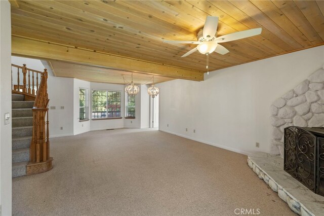 50711 Rd 426, Oakhurst, CA 93644 - unfurnished living room featuring wood ceiling with exposed beams, stairway, carpet flooring, ceiling fan, and a stone fireplace
