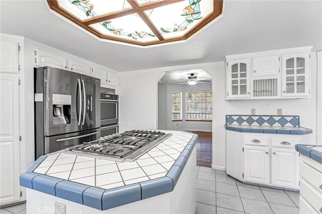 50711 Rd 426, Oakhurst, CA 93644 - kitchen with tile counters, stainless steel appliances, glass insert cabinets, and white cabinetry