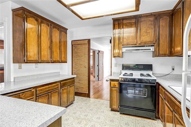 50711 Rd 426, Oakhurst, CA 93644 - kitchen with range with gas stovetop, extractor fan, white refrigerator, and light countertops