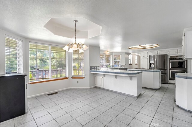 50711 Rd 426, Oakhurst, CA 93644 - kitchen featuring appliances with stainless steel finishes, a peninsula, tile countertops, and light tile patterned floors