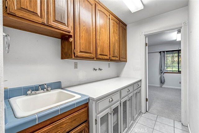 50711 Rd 426, Oakhurst, CA 93644 - laundry room with cabinet space, light tile patterned floors, and light carpet