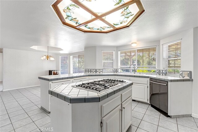 50711 Rd 426, Oakhurst, CA 93644 - kitchen with tile countertops, stainless steel appliances, light tile patterned floors, a chandelier, and a textured ceiling