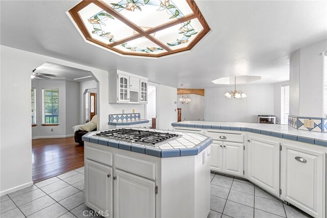50711 Rd 426, Oakhurst, CA 93644 - kitchen with stainless steel gas cooktop, tile countertops, light tile patterned floors, and a chandelier