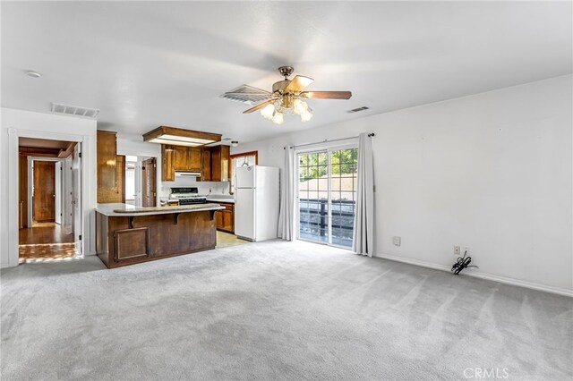 50711 Rd 426, Oakhurst, CA 93644 - kitchen featuring white appliances, range hood, a peninsula, light carpet, and light countertops
