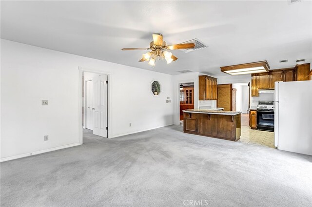 50711 Rd 426, Oakhurst, CA 93644 - kitchen with freestanding refrigerator, range with gas stovetop, open floor plan, ceiling fan, and light countertops