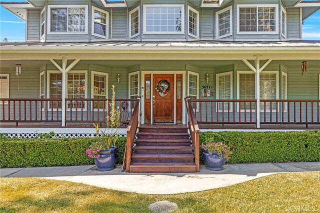50711 Rd 426, Oakhurst, CA 93644 - view of front of home with a standing seam roof, a metal roof, and a porch