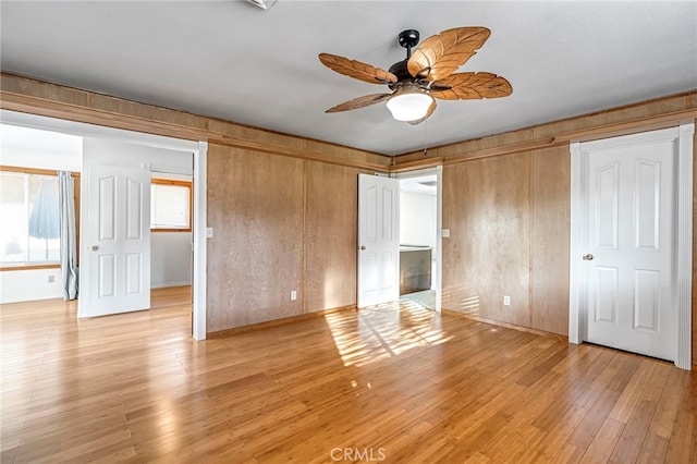 50711 Rd 426, Oakhurst, CA 93644 - unfurnished bedroom with light wood-style flooring, wooden walls, a ceiling fan, and a spacious closet