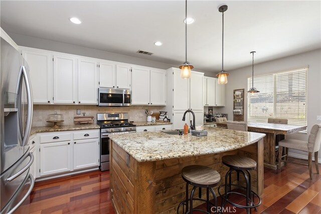 28759 Eridanus Dr, Menifee, CA 92586 - kitchen with stainless steel appliances, a sink, dark wood-type flooring, white cabinets, and light stone counters