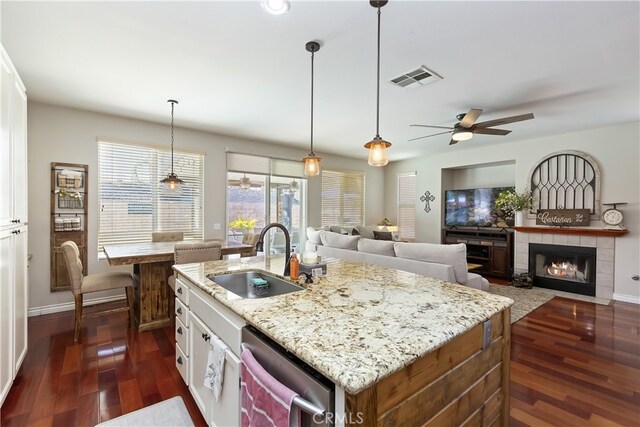 28759 Eridanus Dr, Menifee, CA 92586 - kitchen featuring a sink, stainless steel dishwasher, dark wood finished floors, a ceiling fan, and white cabinetry