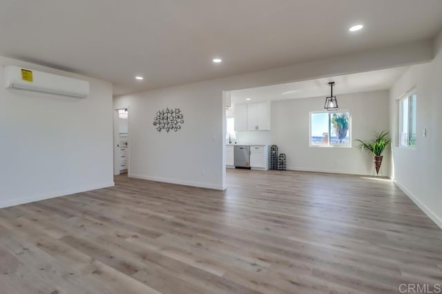 1215 Grand Ave, Spring Valley, CA 91977 - unfurnished living room with a wall mounted AC, light wood-type flooring, recessed lighting, and baseboards