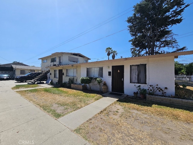 6704 Vinevale Ave, Bell, CA 90201 - view of front facade featuring stairway, stucco siding, and fence