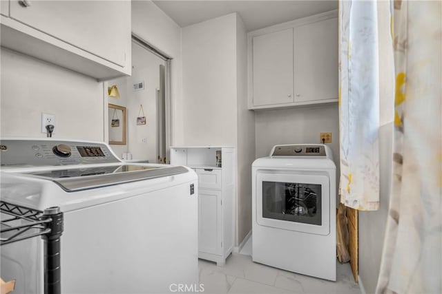 1487 Asbury Dr, Pasadena, CA 91104 - laundry area featuring light marble finish floors, washing machine and clothes dryer, and cabinet space