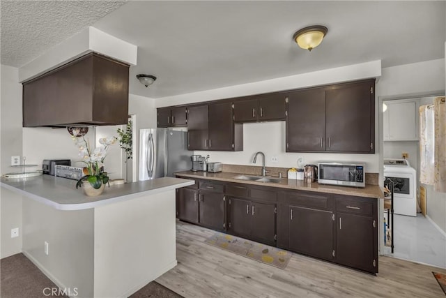 1487 Asbury Dr, Pasadena, CA 91104 - kitchen with stainless steel appliances, washer / dryer, a sink, dark brown cabinetry, and light wood-style flooring