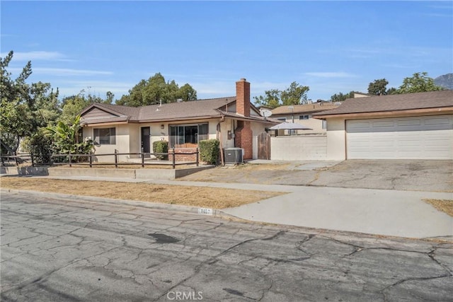 1487 Asbury Dr, Pasadena, CA 91104 - view of front of house featuring cooling unit, fence, stucco siding, concrete driveway, and a chimney