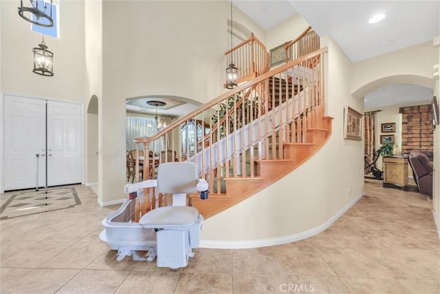43376 Terra Ct, Temecula, CA 92592 - tiled foyer entrance featuring arched walkways, a high ceiling, baseboards, and stairway