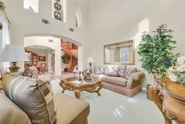 43376 Terra Ct, Temecula, CA 92592 - living area with arched walkways, a high ceiling, stairway, baseboards, and carpet flooring