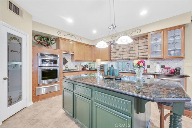 43376 Terra Ct, Temecula, CA 92592 - kitchen featuring a warming drawer, decorative backsplash, stainless steel double oven, green cabinetry, and a kitchen island