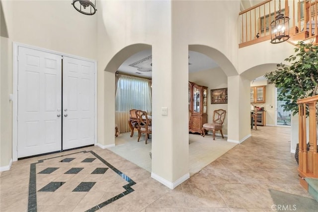 43376 Terra Ct, Temecula, CA 92592 - foyer featuring a high ceiling, arched walkways, baseboards, and light tile patterned floors