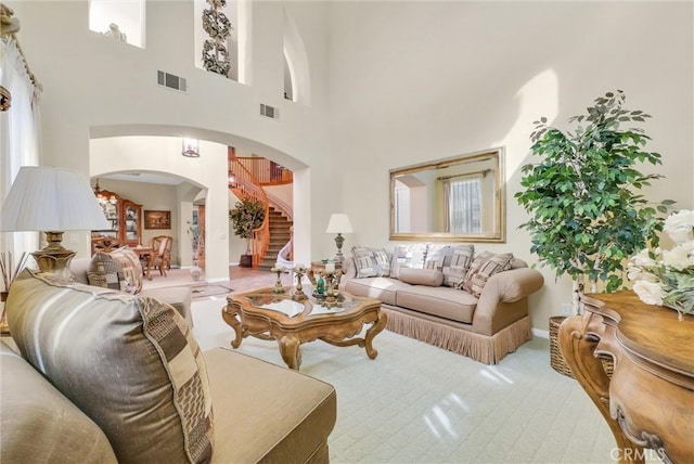 43376 Terra Ct, Temecula, CA 92592 - carpeted living area with arched walkways, a towering ceiling, stairway, and baseboards