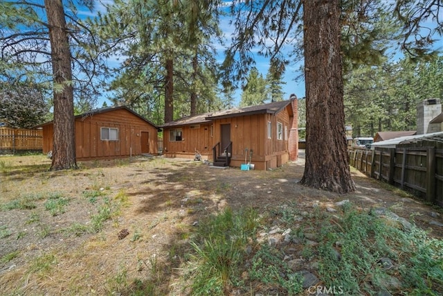 951 Snowbird Rd, Wrightwood, CA 92397 - back of property with entry steps, a chimney, and board and batten siding