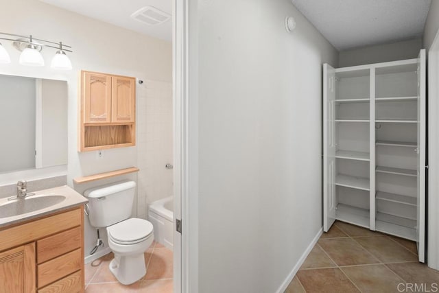 bathroom with toilet, tile patterned flooring, vanity, and a spacious closet
