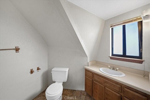 bathroom with toilet, vanity, and an AC wall unit