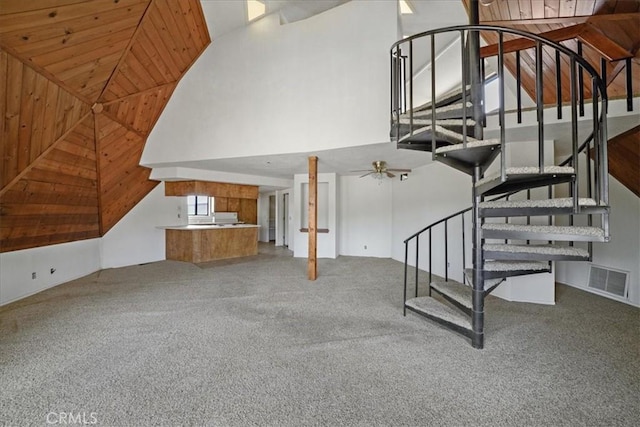stairway featuring carpet floors and high vaulted ceiling