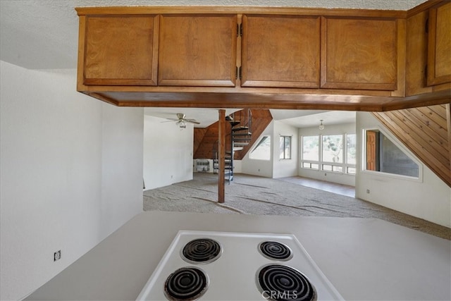 kitchen with brown cabinetry, ceiling fan, and light countertops