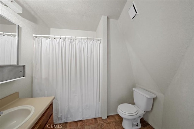 full bathroom with vanity, toilet, a textured ceiling, and a shower with shower curtain