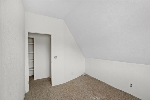 bonus room with carpet floors and vaulted ceiling
