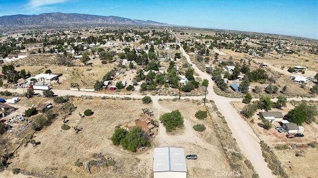 aerial view of property and surrounding area with a mountain backdrop, a desert landscape, and rural landscape