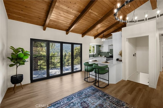 417 Delle Dr, Crestline, CA 92325 - kitchen with wooden ceiling with exposed beams, light countertops, wood finished floors, white cabinets, and a peninsula