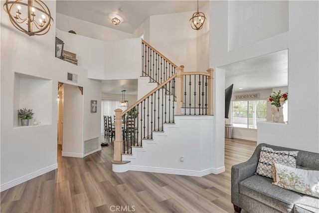 28229 Foothill Rd, Castaic, CA 91384 - stairway with a chandelier, wood finished floors, a high ceiling, and baseboards