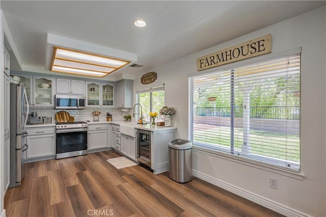 28229 Foothill Rd, Castaic, CA 91384 - kitchen with stainless steel appliances, a sink, baseboards, glass insert cabinets, and light countertops