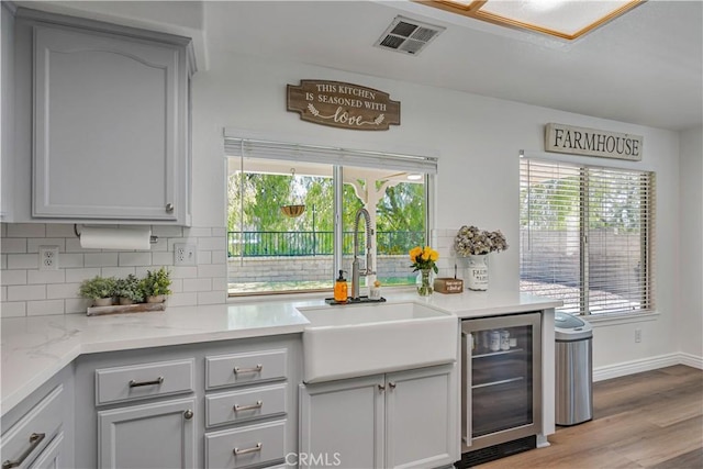 28229 Foothill Rd, Castaic, CA 91384 - kitchen with beverage cooler, gray cabinets, backsplash, and a sink