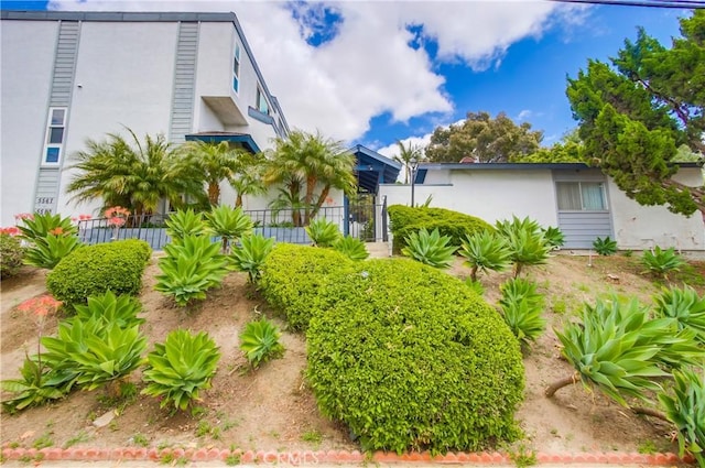 view of front of house featuring stucco siding and fence