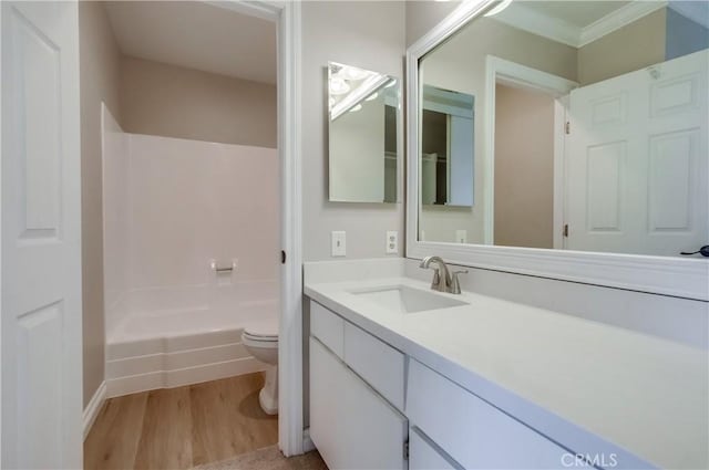 full bathroom with toilet, vanity, wood finished floors, shower / bathtub combination, and crown molding