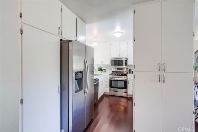 kitchen with stainless steel appliances, dark wood-style flooring, white cabinetry, a sink, and light countertops