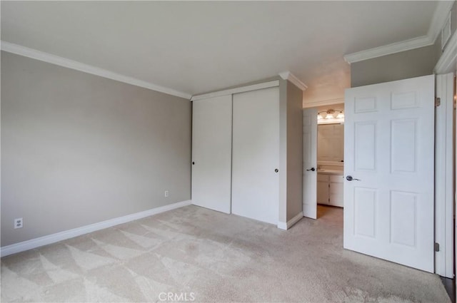 unfurnished bedroom featuring light colored carpet, a closet, crown molding, and baseboards