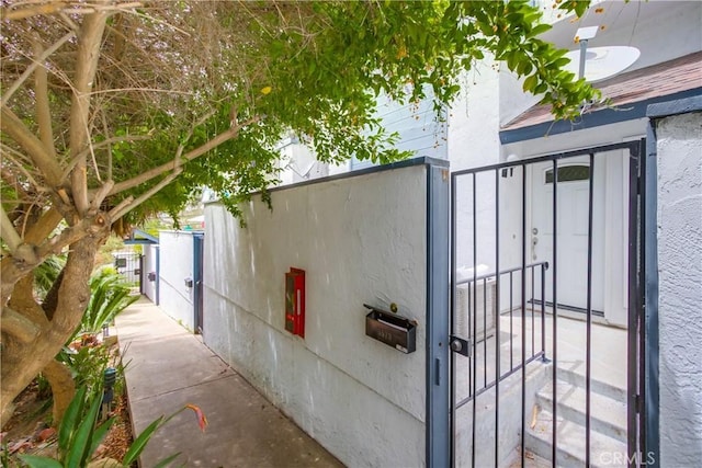 view of side of home with a gate