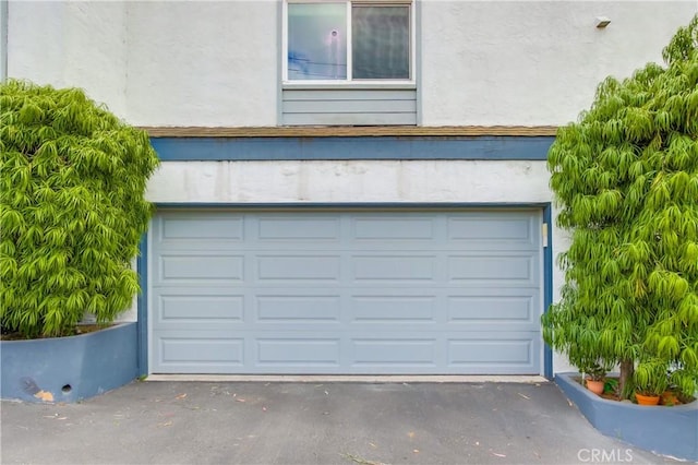 garage featuring asphalt driveway
