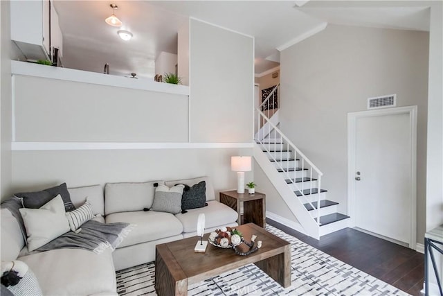 living room featuring dark wood-type flooring, stairs, vaulted ceiling, and baseboards